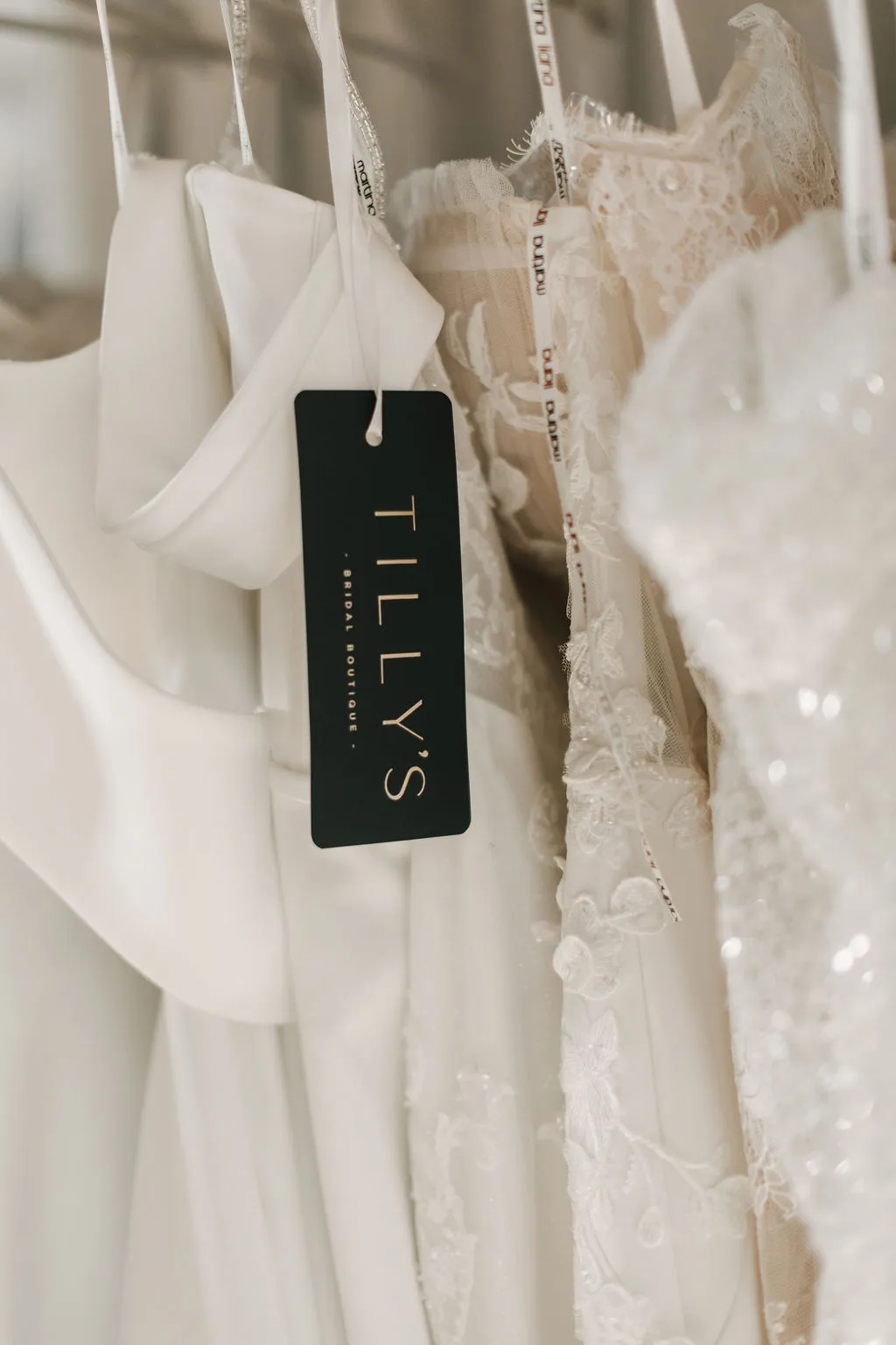 Wedding dresses on a rail at Tily's